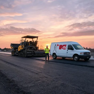 Paving customer lead beside asphalt paver