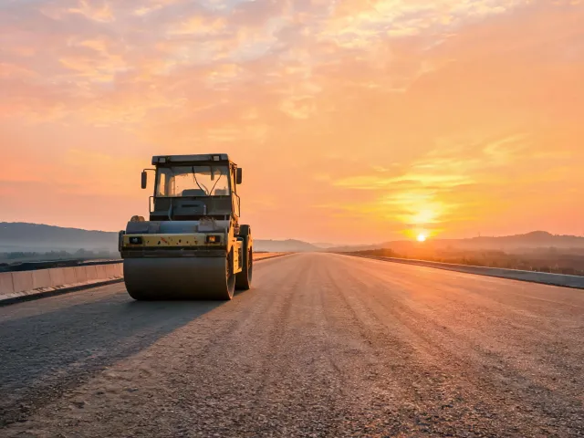 Tandem roller compacting highway base course